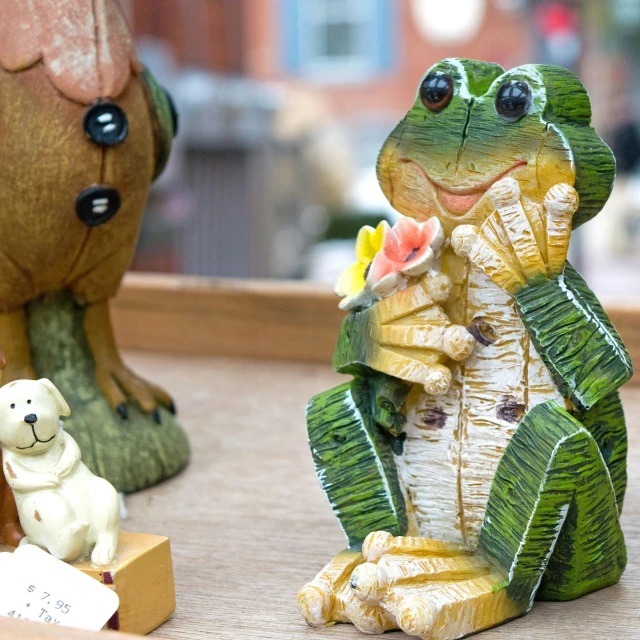 the figurine features a frog with an open mouth, with other toys nearby