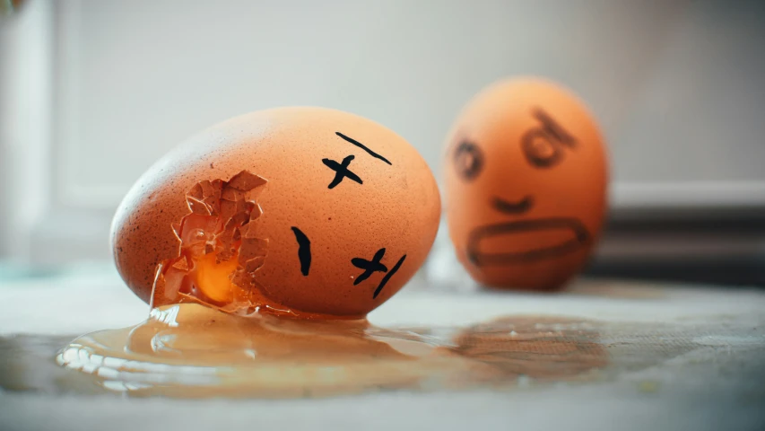 two eggs sitting on a counter with faces drawn on them