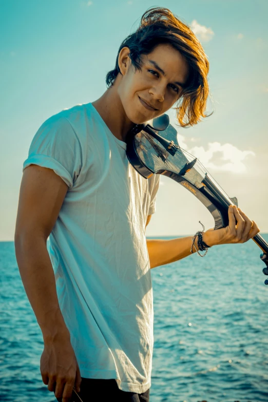 a man holding a small acoustic guitar in one hand