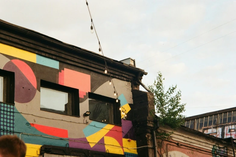 a multicolored building has many windows and signs on the wall