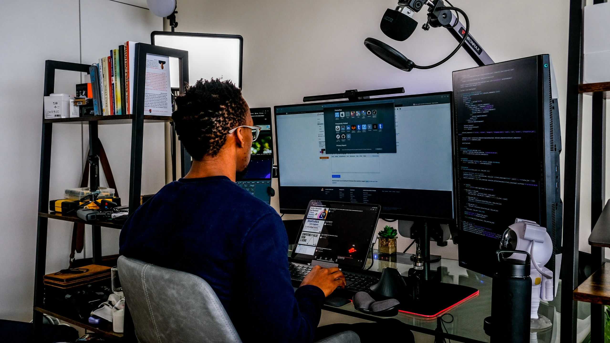 a man sits at a computer desk and looks at the screen