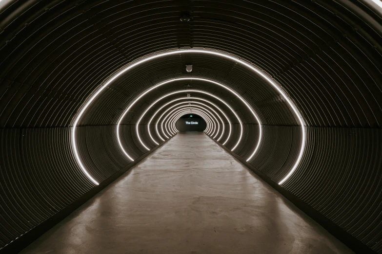 a tunnel with lines in it and light coming through the end