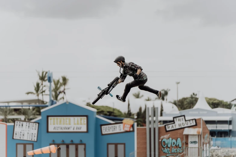 an extreme cyclist flying through the air with his bike