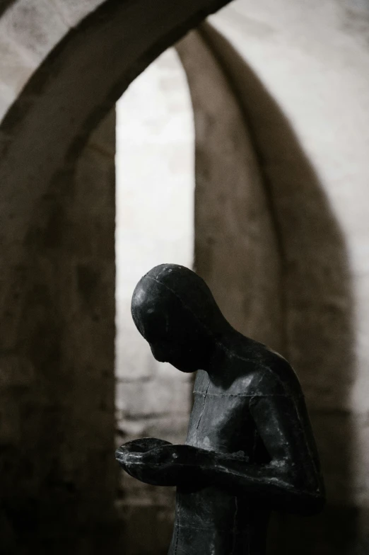 the statue stands next to the arch of an arch holding soing