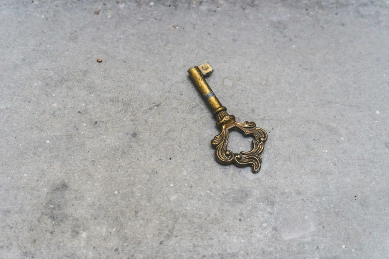 an old antique key on a ground outside