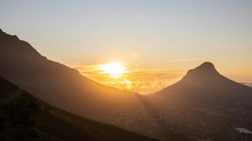 the sun setting over the mountain tops above town