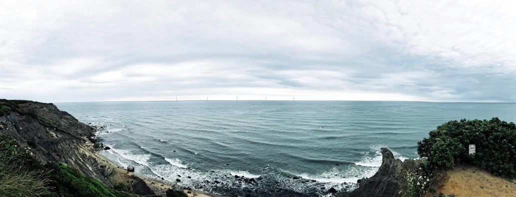 a picture of some very pretty water by a big hill