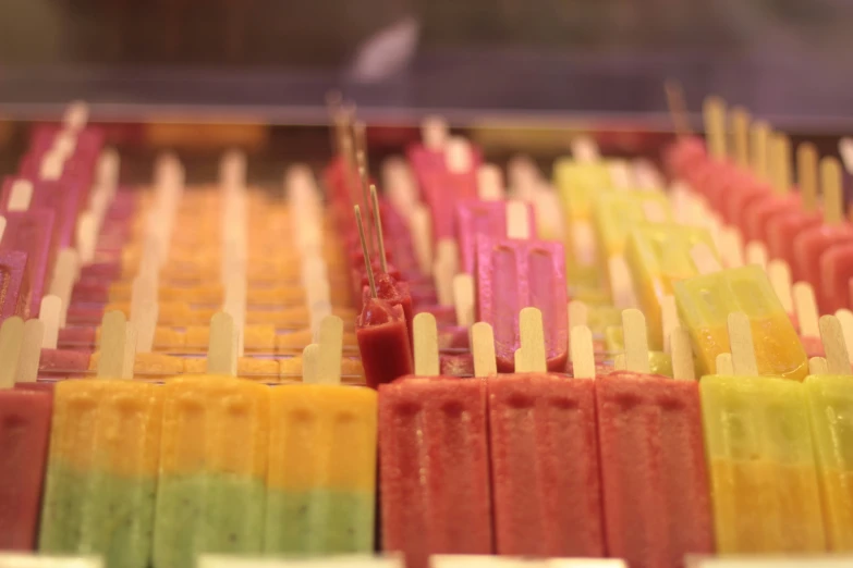 multi - colored popsicles in rows lined up together