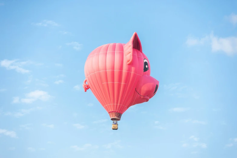 a pig - shaped  air balloon is flying in the blue sky