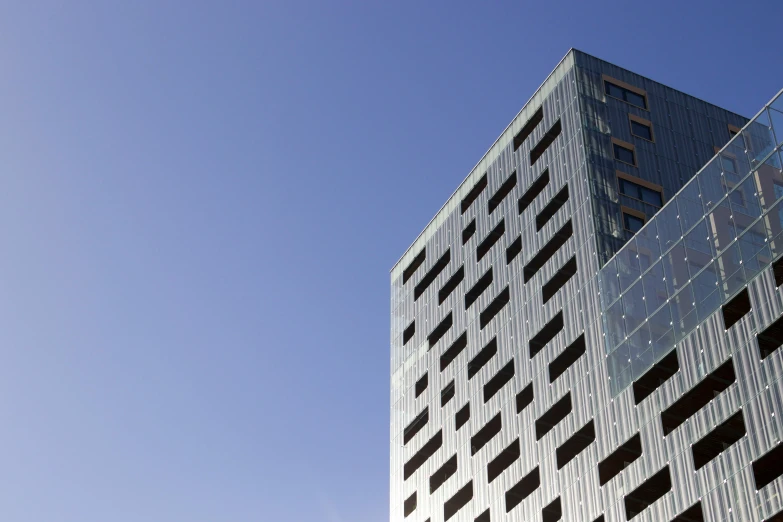 a skyscr in front of blue sky that looks like the back of a tall building