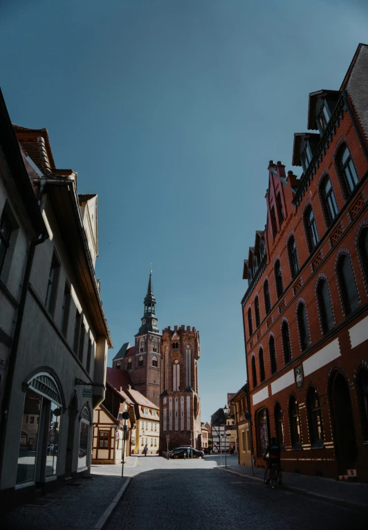 a person riding a bike on a street with buildings in the background