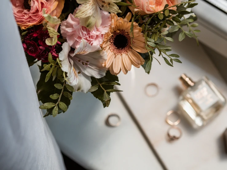 a bouquet of flowers is being held over the window sill