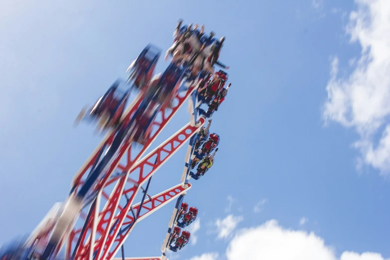 people ride a red ferris ride in a carnival