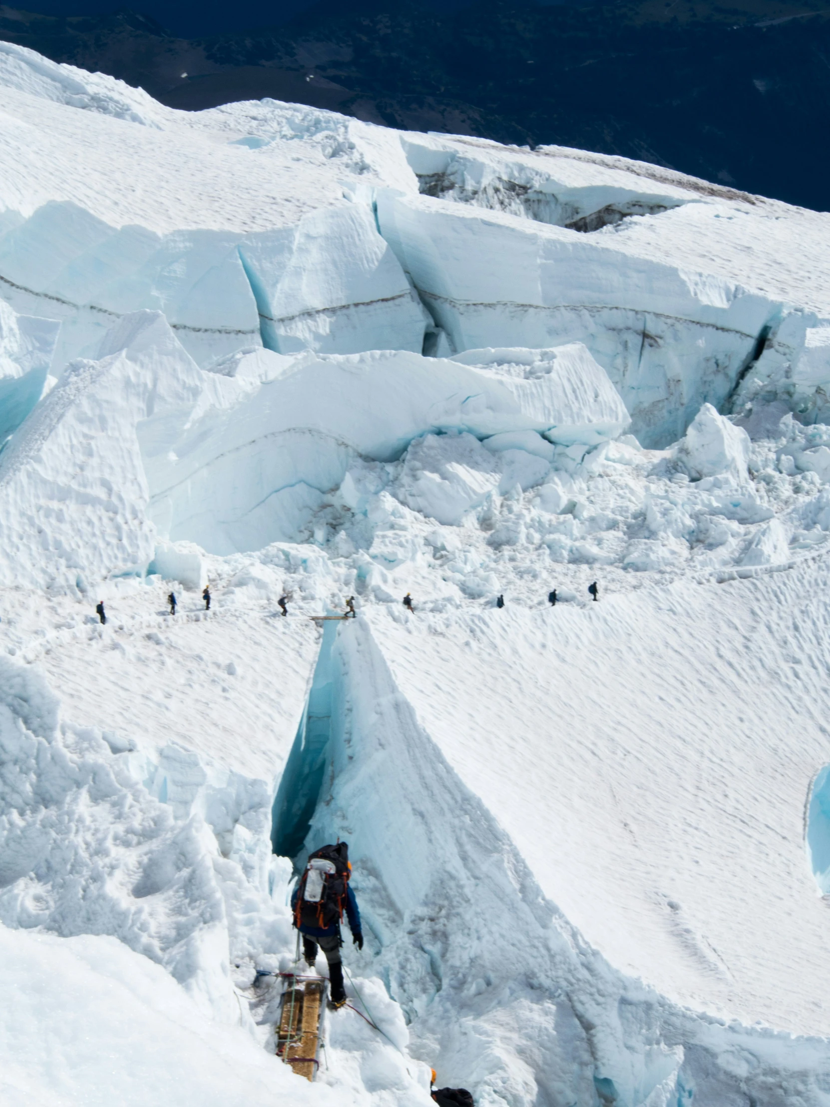 many penguins are nesting at the bottom of this large glacier