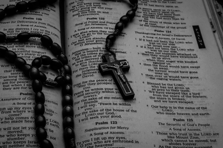 a rosary and chain laying on an open book