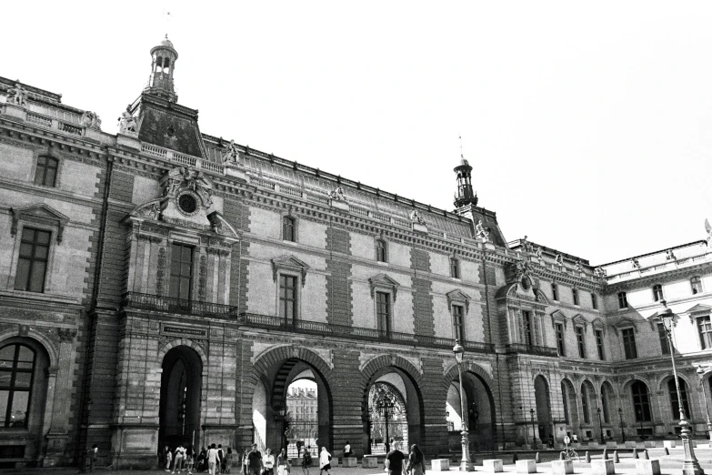 a very large building with arches and a clock tower on top