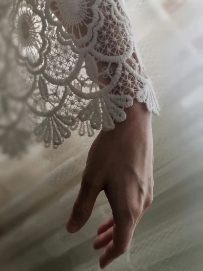 a person holding onto an lace dress and a hand