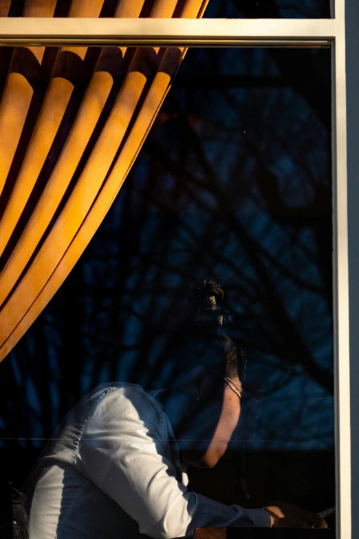 a person sits in front of a large window