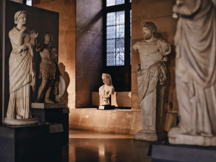 many different statues of men and women in a room