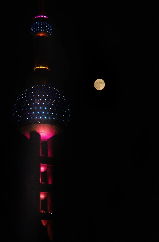 a very tall building with lights lit up in the dark