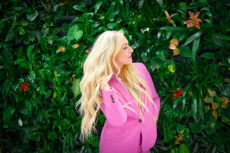 a blonde girl in a pink top looking away from the camera