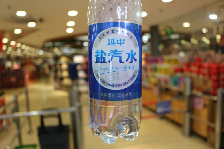 a blue and white bottle is hanging by a rope