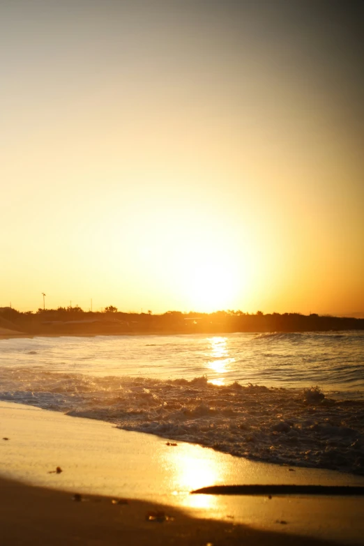 surfer riding on the surfboard while the sun sets