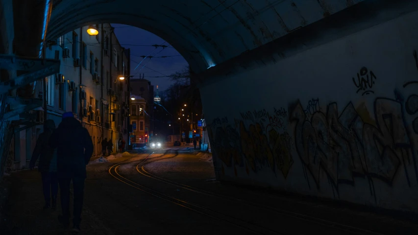 a person standing next to some graffiti on the side of a building