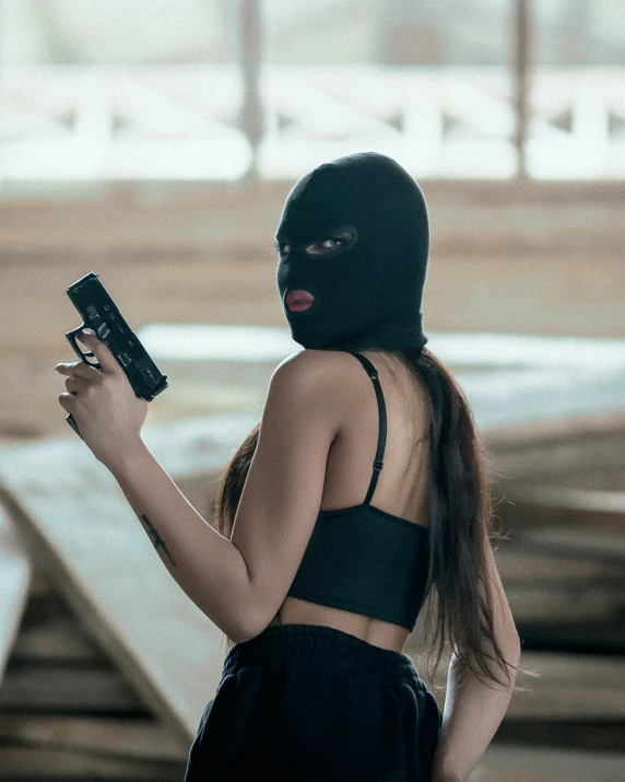 a girl with her black gun looking at her phone
