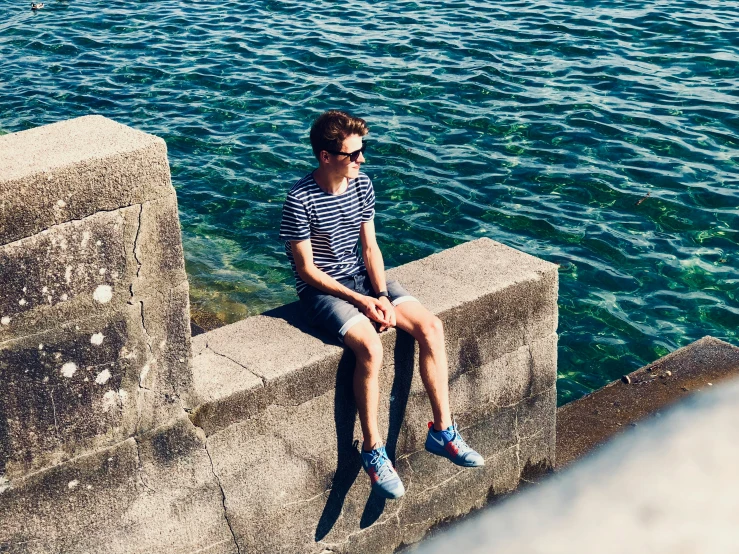 a man with his feet on the water while sitting by himself