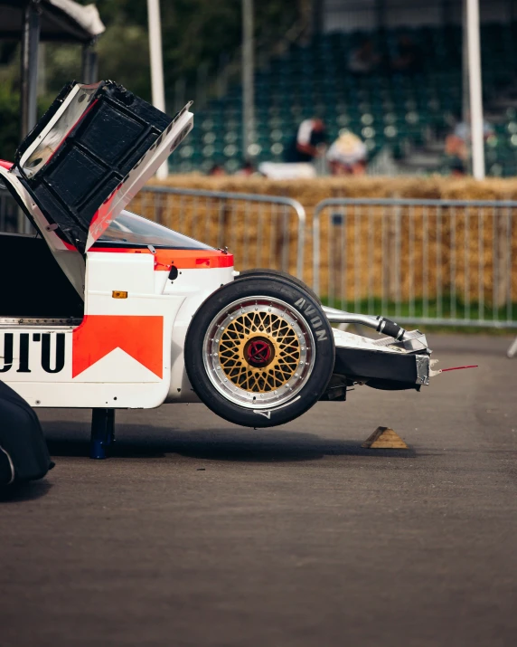 the back end of an old race car, with its hood open