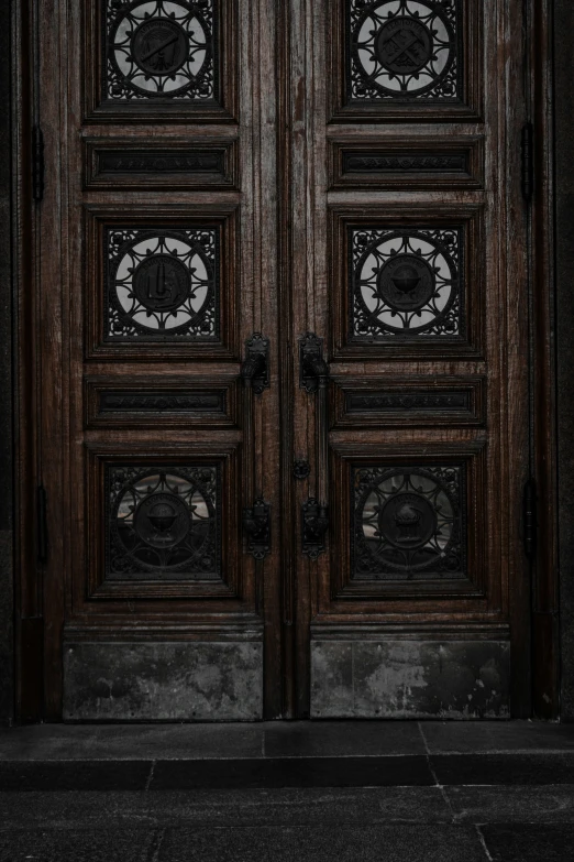 a wooden door has an elaborate iron door 