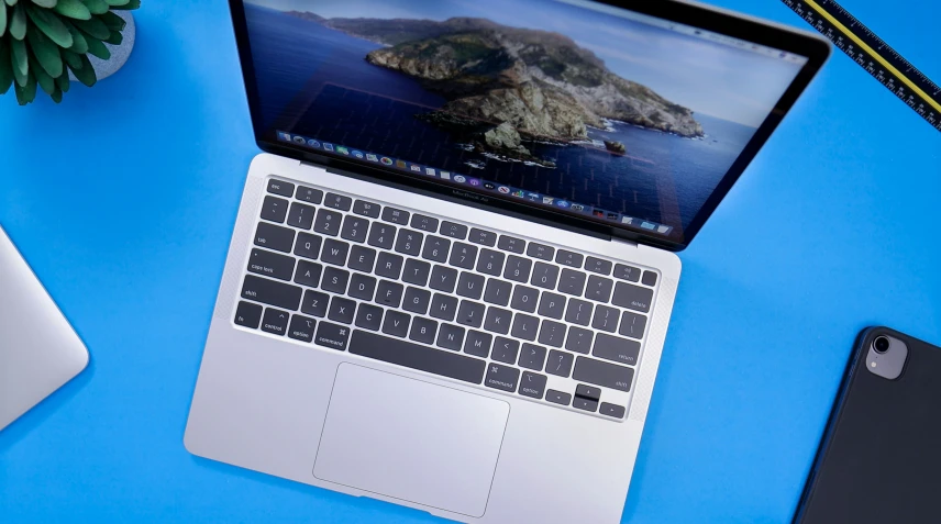 an open laptop computer sitting on top of a blue surface