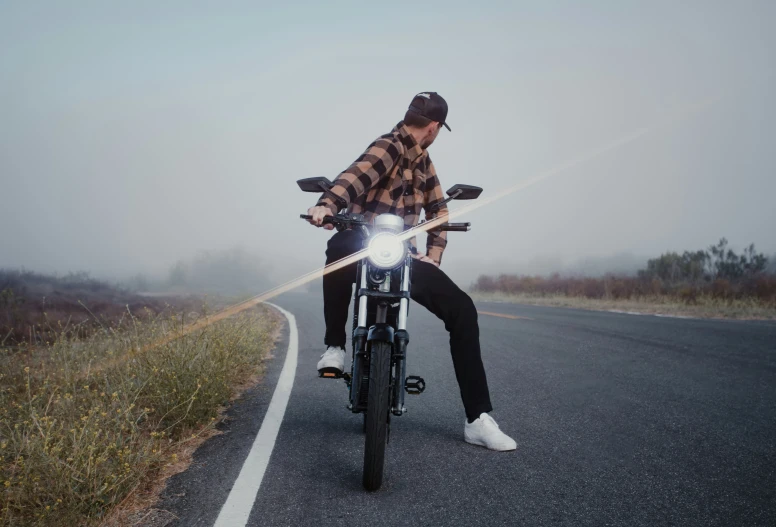 a man on a motorcycle on a foggy road