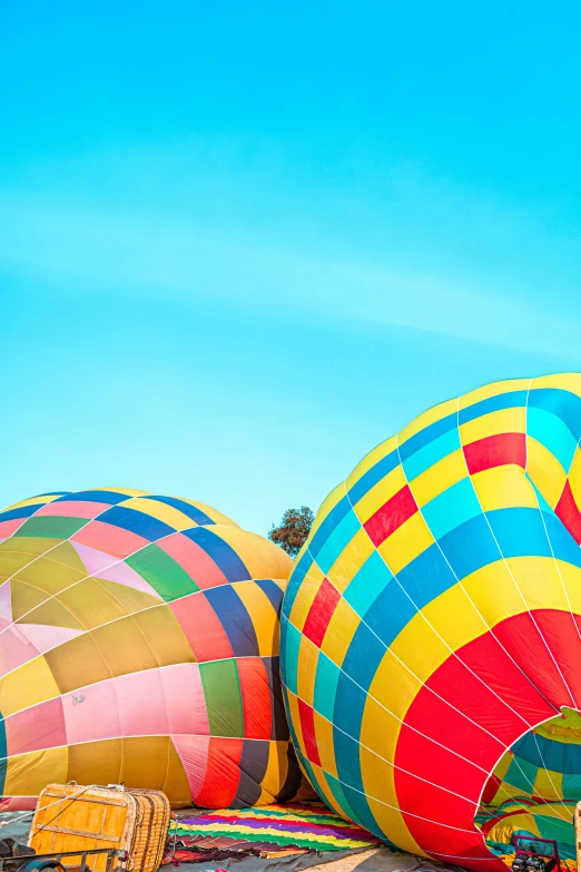 three colorful  air balloons with their large tails sticking out