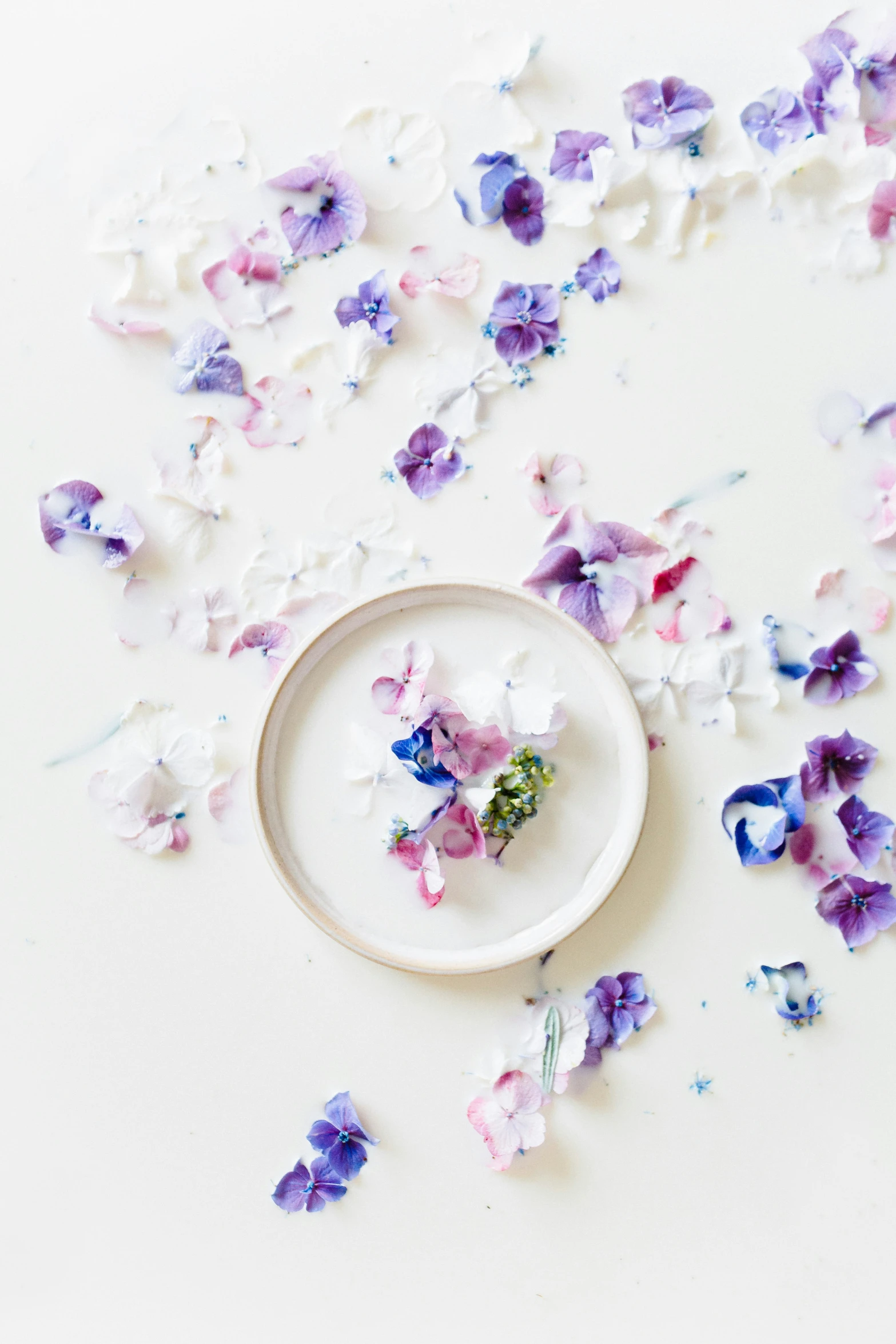 a plate with flower petals in it on a table