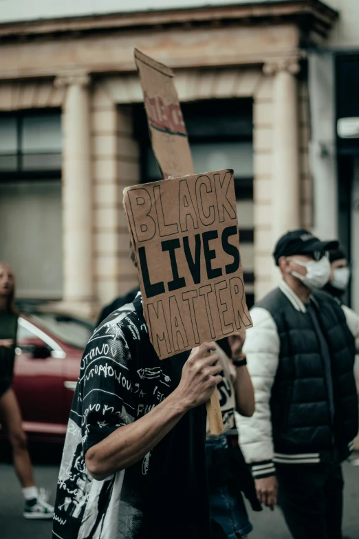 people standing in the street and holding signs