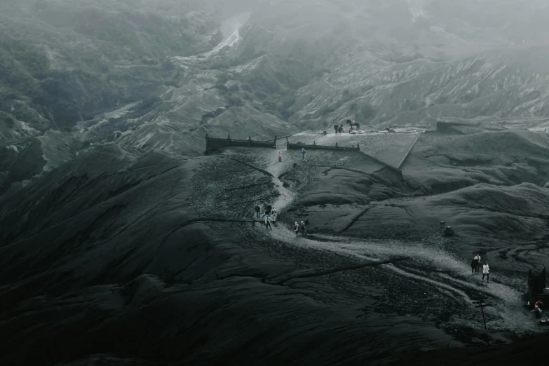 some people walking down a hill in the mist