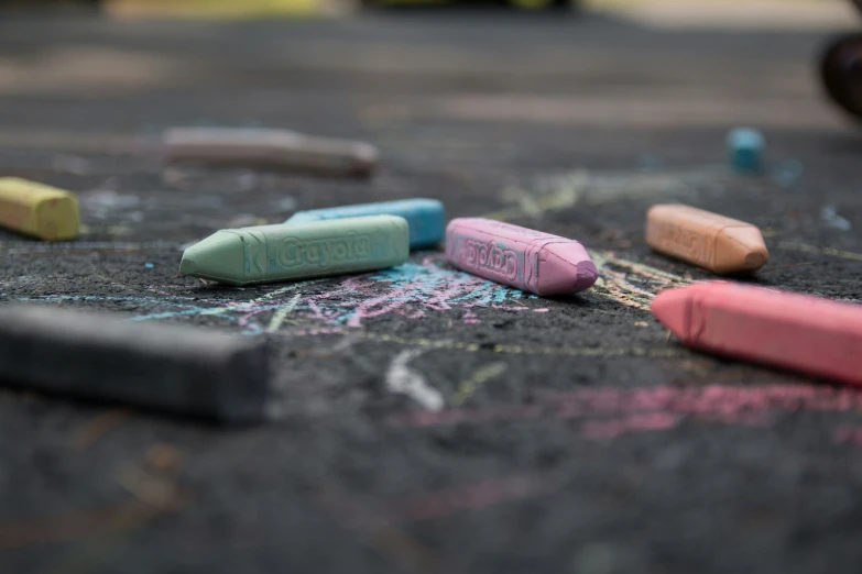 chalk crayons are lying on a table covered in chalk