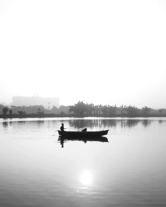 black and white pograph of man paddling his boat