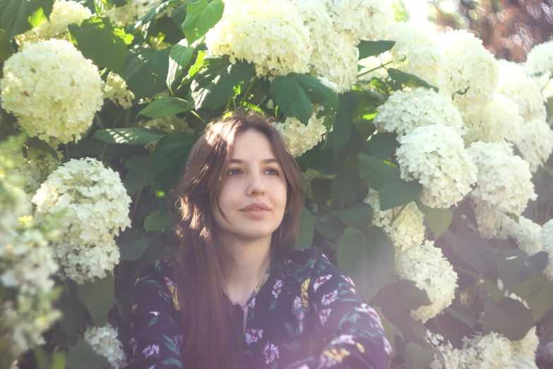 a girl in front of white flowers on tree nch