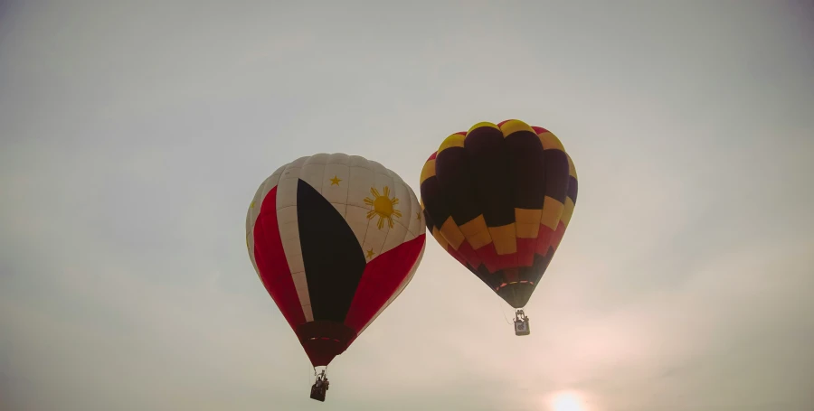 a couple of  air balloons flying in the air