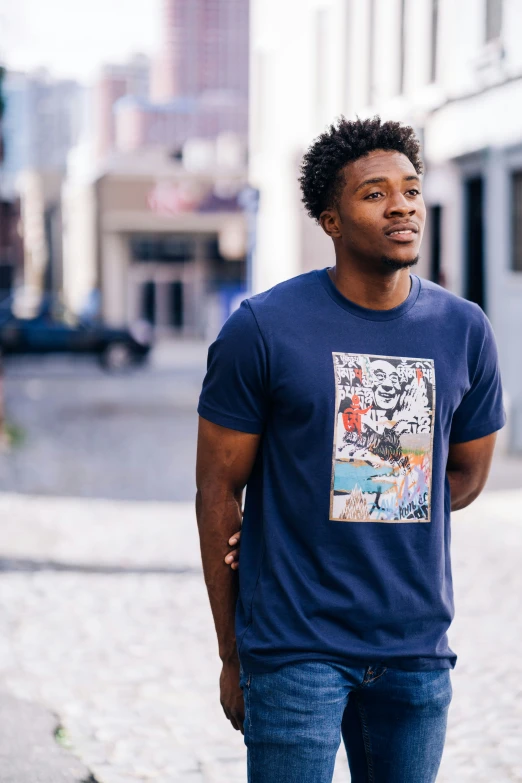 a young man standing in the middle of a street wearing a t - shirt with graffiti on it