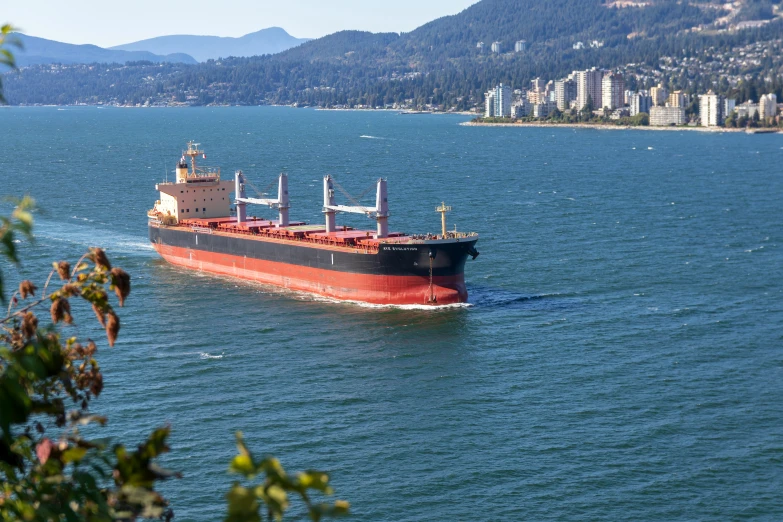 a large ship traveling in the water with buildings behind it