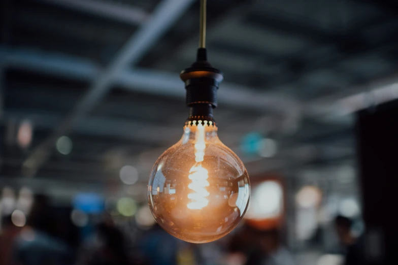 a hanging lightbulb with a christmas tree inside of it