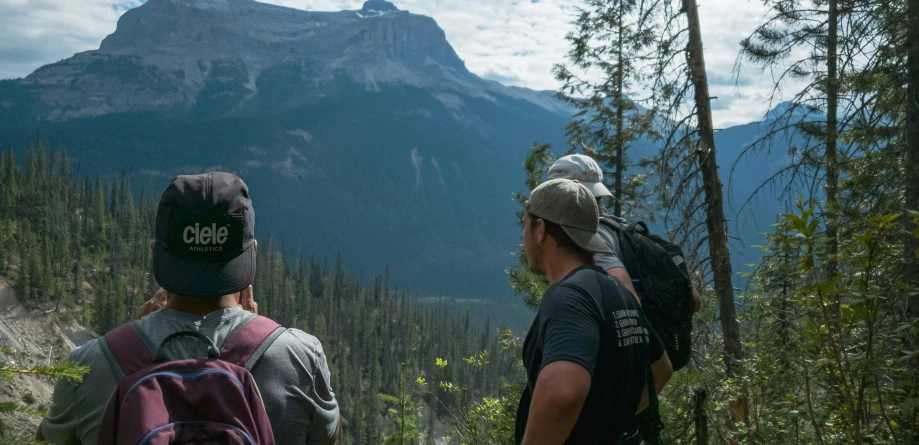 two men in the mountains standing back to back