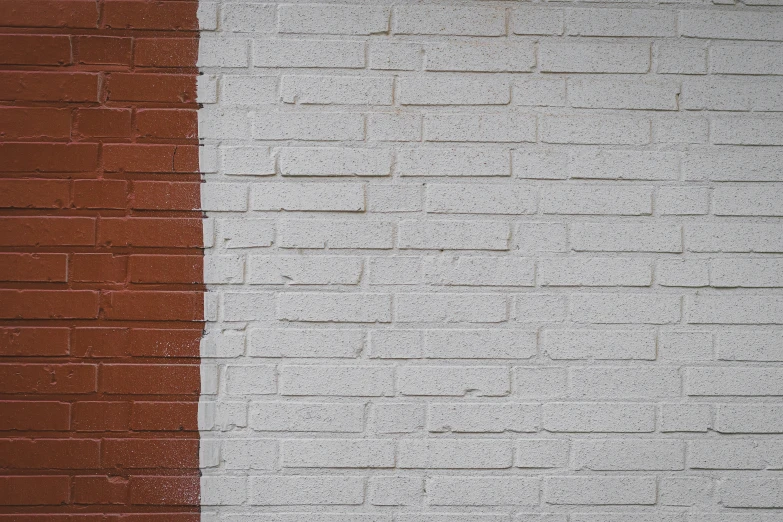 a red fire hydrant standing near a brick wall