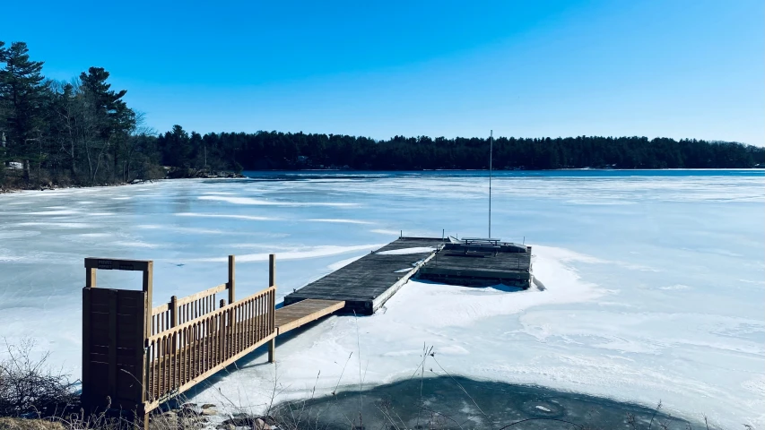 a pier in the snow near some water