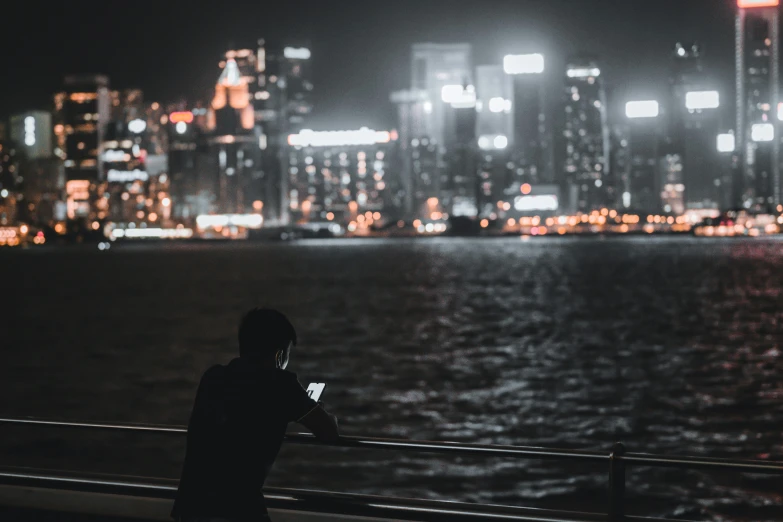 someone taking a picture of some night lights on a bay side