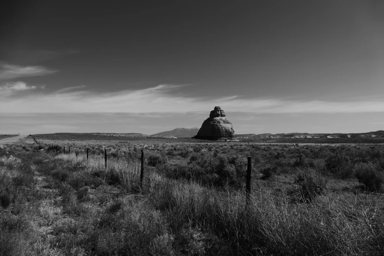 an arid area with a tower near trees and brush